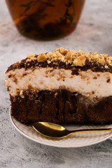A piece of chocolate cake close-up. Dessert spoon. Light background. Vertical.
