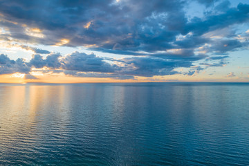 Naklejka na ściany i meble Noting but clouds over water at sunset - aerial view