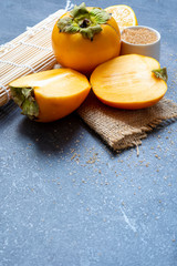 Delicious ripe persimmon fruit on wooden background