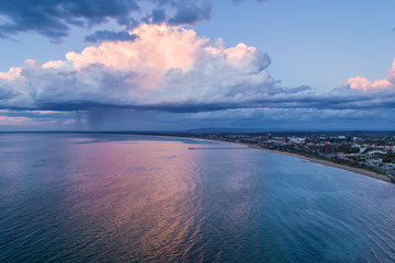 Beautiful clouds and rain over Mornington Peninsula coastline at sunset - aerial view