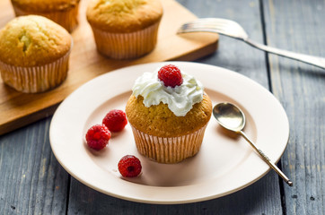 Cupcake with cream and fresh raspberry berries. Muffins on a wooden board.  Homemade pastries, delicious dessert.
