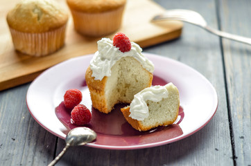 Cupcake with cream and fresh raspberry berries. Muffins on a wooden board.  Homemade pastries, delicious dessert.
