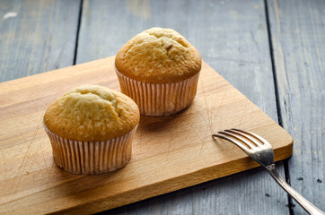 Muffins on a wooden board. Cakes on the table. Homemade pastries, delicious dessert.