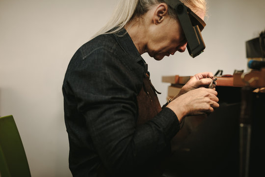 Senior female jeweler making new product - Powered by Adobe