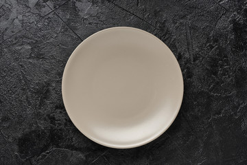 Gray plate on black concrete background.