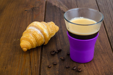 Black coffee in glass cup with croissant