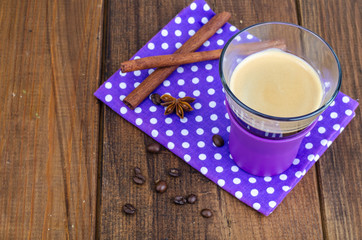 Black coffee in glass cup on napkin, wooden background