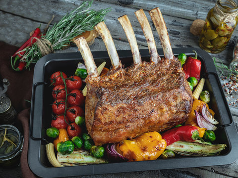 Grilled roasted rack of lamb, with vegetables on the baking sheet