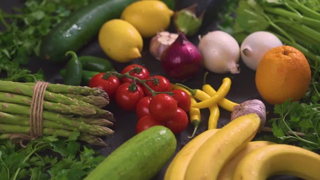 a large set of organic, colorful and fresh vegetables on a black wooden table