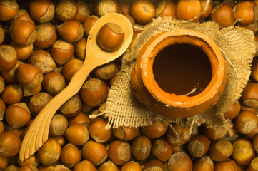 Honey pot with wooden spoon and nuts