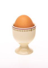 Porcelain egg cup with brown egg inside.