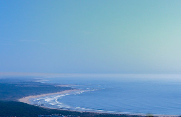 Landscape with mountains, sky, boats, sea, forest and a river in front. beautiful scenery