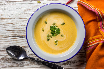 Seasonal autumn food - Spicy pumpkin soup with cream and pumpkin seeds.