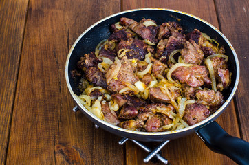 Frying pan with fried chicken giblets. Studio Photo