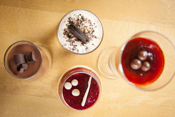 Delicious chocolate,fruit and caramel desserts from top view on wooden background