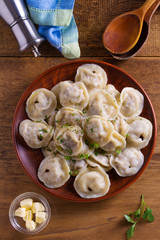 Dumplings, filled with meat, ravioli. Traditional Russian dish pelmeni. Dumplings with filling. View from above, top studio shot