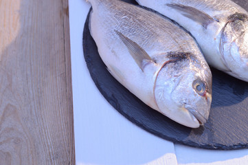 two dorado fish on a black plate
