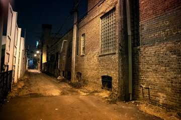 Dark and scary urban city alley with a vintage brick a wall at night