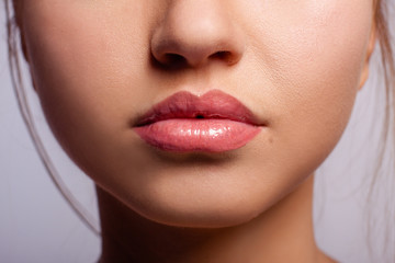 Beautiful lips of the young girl, with the lipstick applied on them