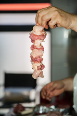 Making kebabs from chicken - raw meat on skewers