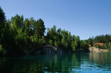 mountain lake in the summer at noon with vacationers and swimming tourists