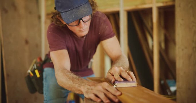 Carpenter uses sanding block to finish beautiful piece of furniture