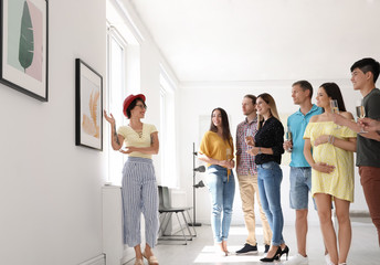 Group of people with guide at exhibition in art gallery