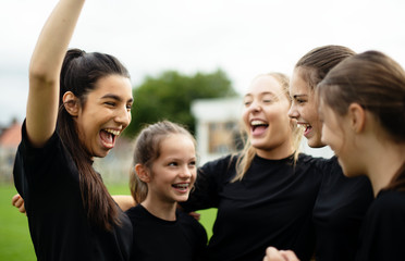 Cheerful female football players celebrating their victory