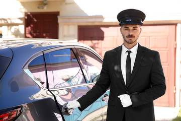 Naklejka premium Young handsome driver standing near luxury car. Chauffeur service