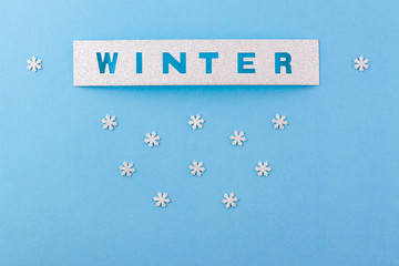 Confetti and handmade lettering scrabbooking in the form of an inscription WINTER and small snowflakes.