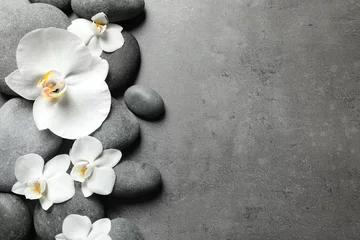 Deurstickers Plat lag compositie met spa stenen en orchideebloemen op grijze achtergrond. Ruimte voor tekst © New Africa