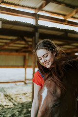 Girl grooming a chestnut horse