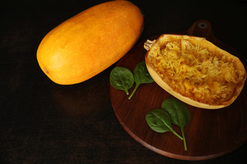 pumpkin spaghetti with spinach on a brown wooden background with copy space for text or image. Flat lay. Top view.