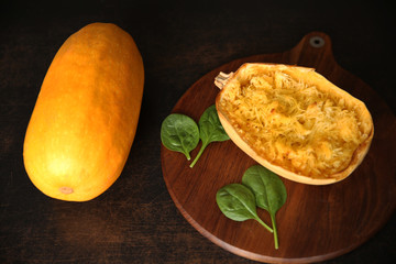 pumpkin spaghetti cooked and raw on the brown background with copy space for text or image. Flat lay. Top view.