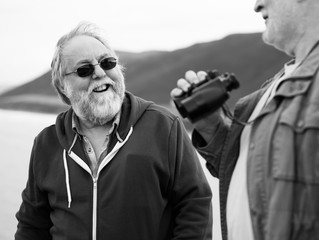 Senior men standing together with a pair of binoculars