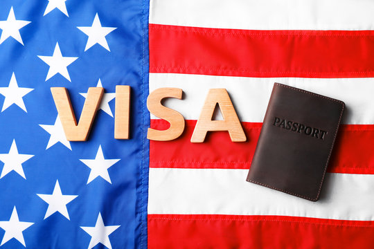 Flat lay composition with passport and word VISA on flag of USA