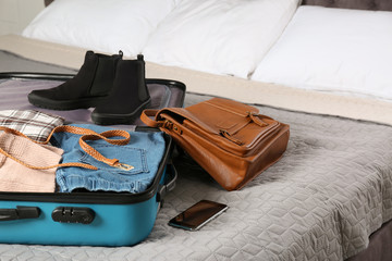 Suitcase packed for trip on bed in room