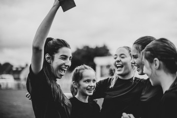 Cheerful female football players celebrating their victory - obrazy, fototapety, plakaty