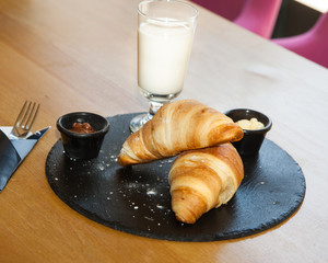 A couple of croissants and a glass of milk