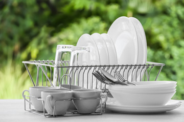 Set of clean dishware on table against blurred background
