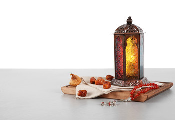 Fototapeta premium Muslim lamp, dates and prayer beads on table against white background. Space for text