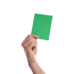 Football referee holding green card on white background, closeup