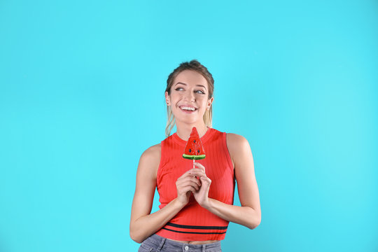 Young pretty woman with candy on colorful background