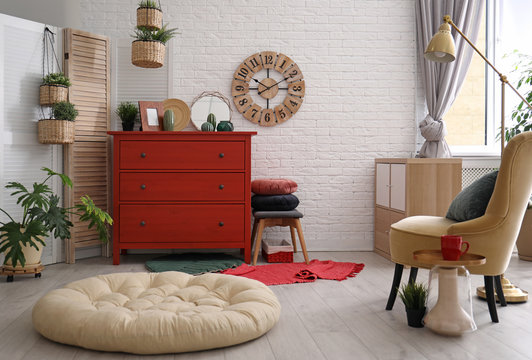 Stylish room interior with chest of drawers and pet bed