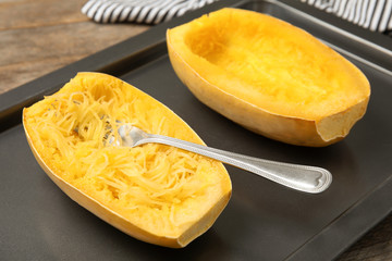 Cooked spaghetti squash and fork on baking sheet