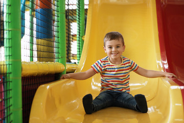 Cute little child playing at indoor amusement park