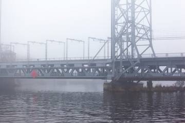 big metal bridge in thick heavy fog