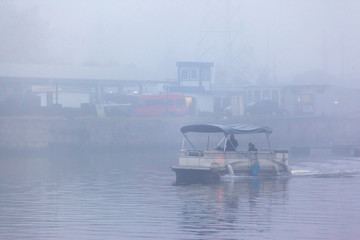 pleasure boat floats on the river in heavy fog