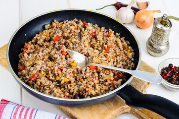 Buckwheat porridge with vegetables in pan