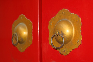 copper door knocker on the red door plank, China